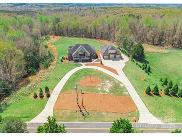 An aerial view showcases a home, detached garage and driveway, all surrounded by a lush, green landscape at 2236 Tuckaway Rd, Rock Hill, SC 29730