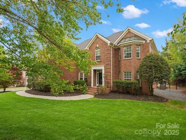 Beautiful brick home with a well-manicured lawn and lush landscaping at 3100 Stanway Ct, Waxhaw, NC 28173