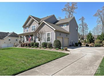 Charming two-story home with a manicured lawn, two-car garage, and inviting front porch at 7240 Baybrooke Ln, Harrisburg, NC 28075