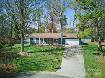 Charming single-story home with a well-manicured front lawn and a paved driveway leading to an attached garage at 7656 Eastbourne Rd, Charlotte, NC 28227