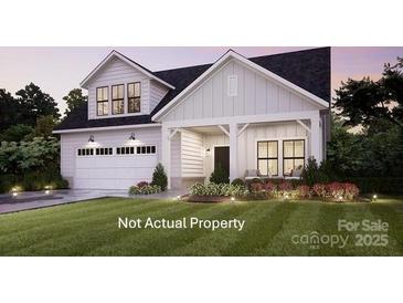 Charming two-story home with manicured lawn, inviting front porch, and attached garage at 8135 Stillhouse Ln # 28, Harrisburg, NC 28075