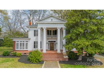 Stately white home featuring grand columns, a brick staircase, and a well-manicured front yard at 8425 E Franklin St, Mount Pleasant, NC 28124