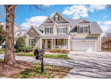 Charming two-story home with lush landscaping, a porch, and a two-car garage at 1027 Brookline Dr, Huntersville, NC 28078