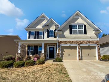 Charming two-story home featuring stone accents, a covered front porch, and an attached two-car garage at 111 Canada Dr, Statesville, NC 28677