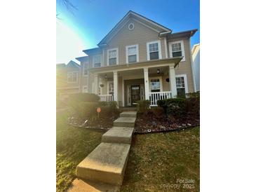 Charming two-story home featuring a welcoming front porch with white columns and landscaped front yard at 13127 Centennial Commons Pkwy, Huntersville, NC 28078