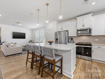 Spacious kitchen with modern appliances, a large island, and open living space at 1542 Cedar Tree Dr, Belmont, NC 28012