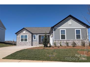 Beautiful single-story home featuring stone accents, gray siding, manicured lawn, and a paved driveway at 2063 Fordhill St, Rock Hill, SC 29732