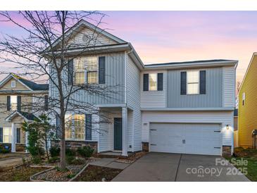 Charming two-story home featuring stone accents, a covered front porch, and an attached two-car garage at 2009 Amos Oaks Ln, Charlotte, NC 28215