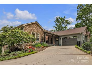 Inviting home with stone accents, manicured landscaping, and a spacious driveway at 298 Poplar Grove Ct, Taylorsville, NC 28681