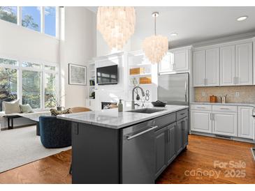 Modern kitchen featuring a large island, stainless steel appliances, and hardwood floors that blend style with functionality at 415 Spring St, Davidson, NC 28036