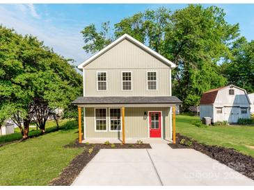 Charming two-story home with a bright red front door, inviting curb appeal and well-manicured landscaping at 570 Key West Ave, Kannapolis, NC 28081