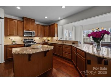 Modern kitchen with granite countertops, stainless appliances, and wood flooring offers luxury living at 6004 Clover Hill Rd, Indian Trail, NC 28079