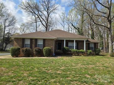 Charming brick home with a well-manicured front lawn, shutters, and classic architectural details at 8411 Rhian Brook Ln, Charlotte, NC 28216