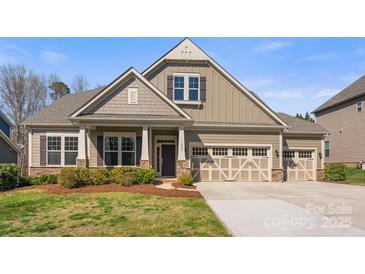 Charming two-story home featuring a well-manicured lawn and a three-car garage at 11037 Thornbeck Ln, Midland, NC 28107