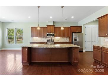 Island kitchen featuring granite countertops, stainless steel appliances, and ample cabinet space at 11037 Thornbeck Ln, Midland, NC 28107