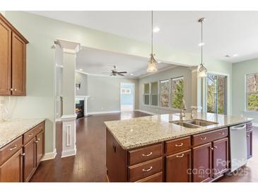 Modern kitchen features stainless appliances, a granite island, and an open floorplan to living room at 11037 Thornbeck Ln, Midland, NC 28107