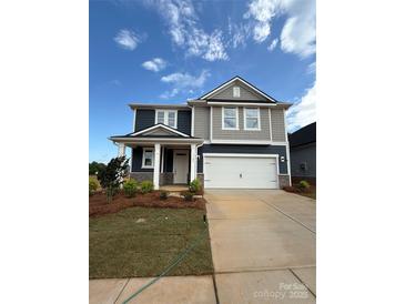 Two-story home boasts a symmetrical facade with a two-car garage and covered front porch at 309 Knotty Wood Dr # 78, Monroe, NC 28110