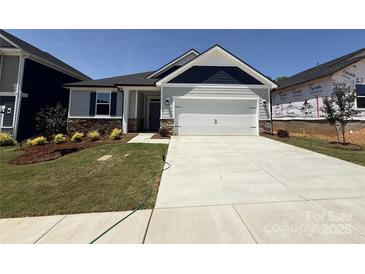 Charming single-story home featuring manicured landscaping and a spacious two-car garage in a desirable neighborhood at 313 Knotty Wood Dr # 79, Monroe, NC 28110