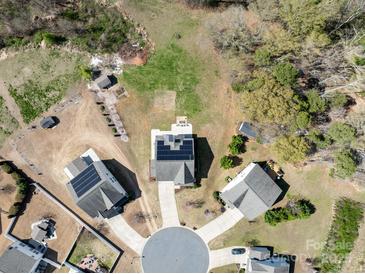 Aerial view of a neighborhood with well-maintained houses with solar panels and tree coverage at 8137 Bryson Rd, Fort Mill, SC 29707