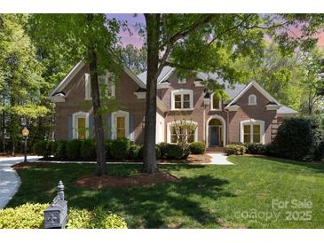 Stately brick home with manicured lawn, mature trees, and inviting entrance showcasing classic elegance and curb appeal at 10602 Country Squire Ct, Matthews, NC 28105