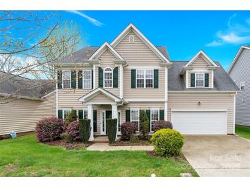 Charming two-story home boasts manicured lawn and lush landscaping at 119 Tilton Dr, Mooresville, NC 28115