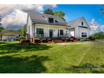 Stunning two-story home featuring black trim, a charming front porch, and lush green lawn at 1300 Aragon Beach Rd, Rock Hill, SC 29732