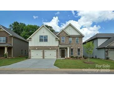 Beautiful two-story brick home with a two-car garage and well-manicured lawn at 136 Asmodean Ln, Troutman, NC 28166