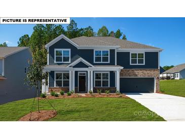 Inviting two-story home with a combination of siding and brick accents, enhanced by a well-manicured front lawn at 134 Asmodean Ln, Troutman, NC 28166