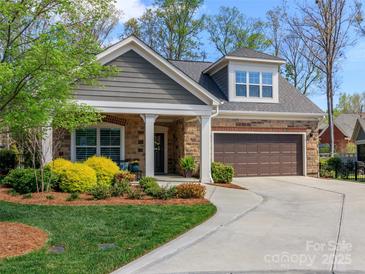 Charming home featuring a manicured front yard, stone and siding exterior, and an attached garage at 2342 Wesley Landing Rd, Waxhaw, NC 28173
