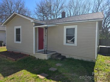 Charming single-story home with light beige siding, a red door, and a neatly landscaped front yard at 325 Orr Dr, Rock Hill, SC 29730