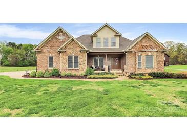 Beautiful brick and stone home featuring a well-manicured lawn and inviting front porch at 4205 New Town Rd, Waxhaw, NC 28173