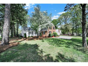 Charming home with a well-manicured lawn and mature trees, providing ample shade and curb appeal at 4601 Crooked Oak Ln, Charlotte, NC 28226