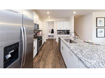 Modern kitchen featuring white cabinetry, granite countertops, stainless steel appliances, and hardwood flooring at 7865 Iron Rd, Sherrills Ford, NC 28673