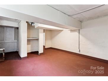 Unfinished basement space with concrete walls and floors, with visible pipes and support beams at 813 North Ave, Charlotte, NC 28208