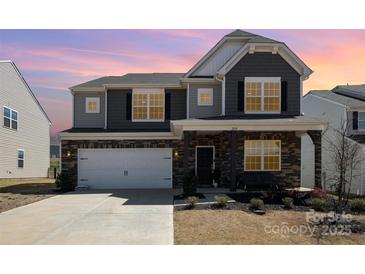 Charming two-story home featuring a mix of stone and siding, attached two-car garage and a welcoming front porch at 2039 Morning Gold Dr, Maiden, NC 28650