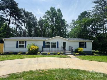 Charming single-story home with blue shutters, manicured landscaping, and concrete driveway at 166 Brook Creek Dr, Troutman, NC 28166