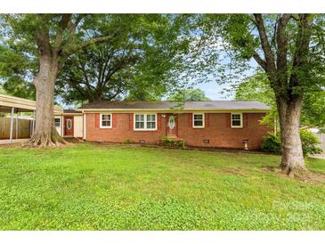 Charming red brick home with mature trees and a well-manicured lawn at 4107 Windwood Dr, Gastonia, NC 28056