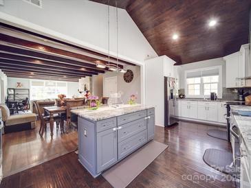 Bright kitchen features a center island, stainless steel appliances, and beautiful hardwood floors at 605 Allen Way, Indian Trail, NC 28079