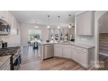 Modern kitchen featuring stainless steel appliances, granite countertops, and a breakfast bar at 16718 Keene Ct, Charlotte, NC 28278