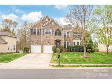 Charming brick two-story home featuring a two-car garage and a green front yard at 8033 Penman Springs Dr, Waxhaw, NC 28173
