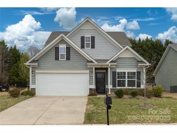 Charming two-story home with a gray exterior, a well-manicured lawn, and a two-car garage at 1415 Troon Dr, Salisbury, NC 28144