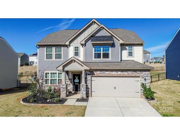 Charming two-story home with stone accents, inviting entrance, and attached two-car garage at 154 Rooster Tail Ln, Troutman, NC 28166