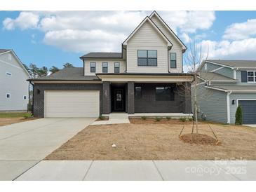 New construction two-story home featuring a brick veneer, attached garage, and covered front porch at 163 Windy Dell Dr, Tega Cay, SC 29708
