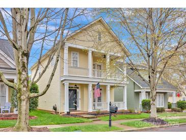 Charming two-story home with a welcoming porch, manicured lawn, and classic architectural details at 16606 Spruell St, Huntersville, NC 28078