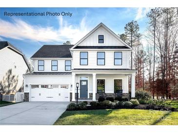 Charming two-story home showcasing a well-manicured lawn, two-car garage, and a welcoming front porch with rocking chairs at 3010 Bramble Hedge Rd # 3271, Indian Trail, NC 28079