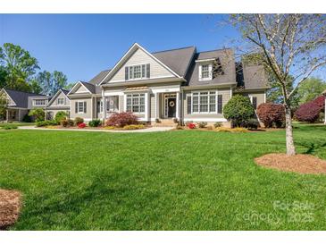 Charming home featuring a manicured lawn, neutral siding, dark shutters, and a welcoming front porch at 315 Muirfield Way, Salisbury, NC 28144