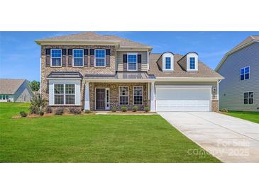 Inviting two-story home showcasing a brick facade, well-manicured lawn, and a two-car garage at 3886 Horsham St, Indian Land, SC 29707