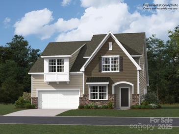 New two-story home with stone accents, attached garage and beautiful yard with lush landscaping and driveway at 4171 Skyboat Cir, Fort Mill, SC 29715