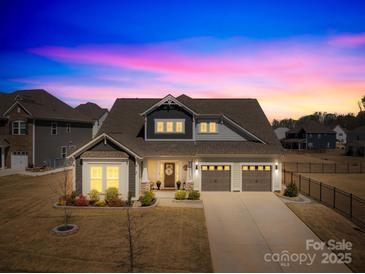 Charming two-story home featuring a landscaped yard, a two-car garage and beautiful lighting at 7313 Glenroe Dr, Huntersville, NC 28078