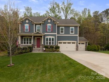 Charming two-story home with a landscaped yard, featuring a three-car garage and a welcoming front porch at 1041 Crofton Dr, Waxhaw, NC 28173